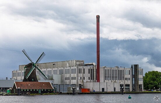 Amsterdam2025-024 Walking across the bridge from Zaandijk to Zaanse Schans is this juxtaposition of old and new technology. The windmill was used to grind vegetable oils...
